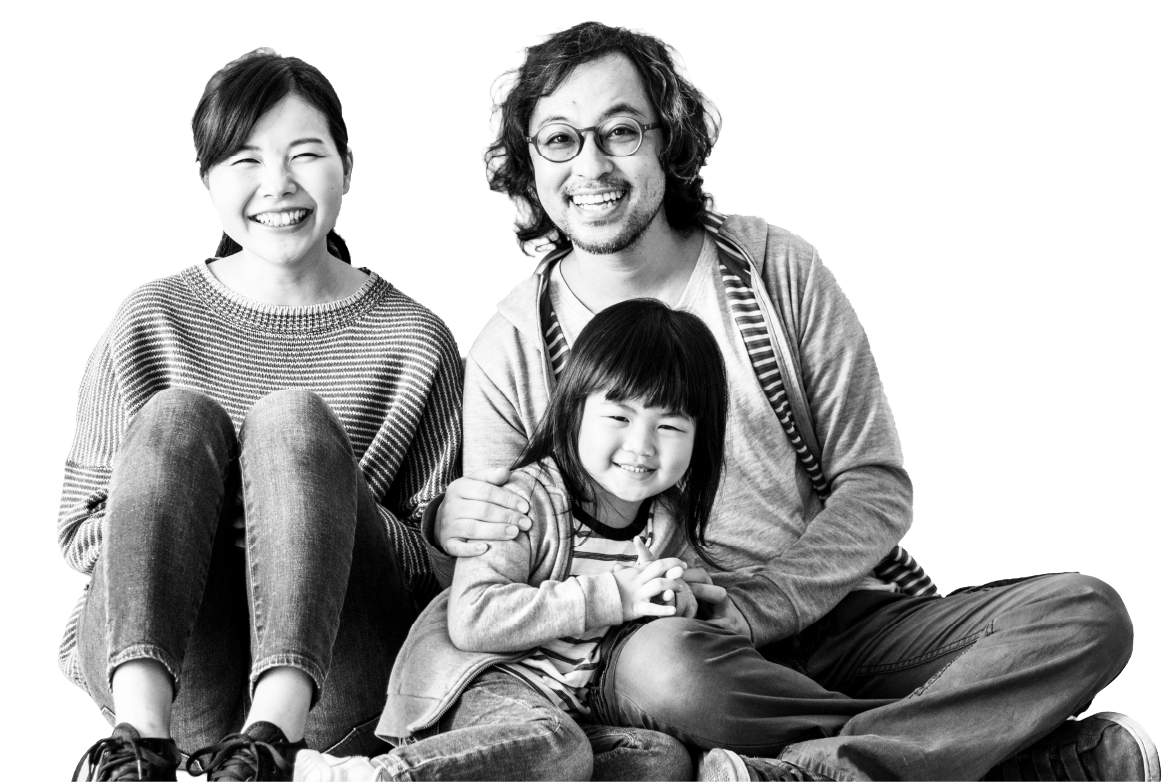 Una familia de tres sentada junta y sonriendo