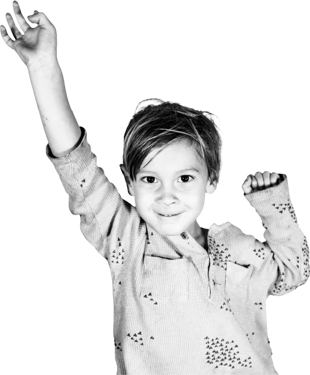 A young boy cheering with his fist in the air